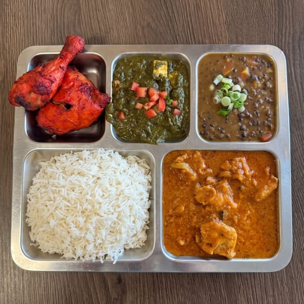 Indian thali with tandoori chicken, palak paneer, dal makhani, butter chicken, and basmati rice.